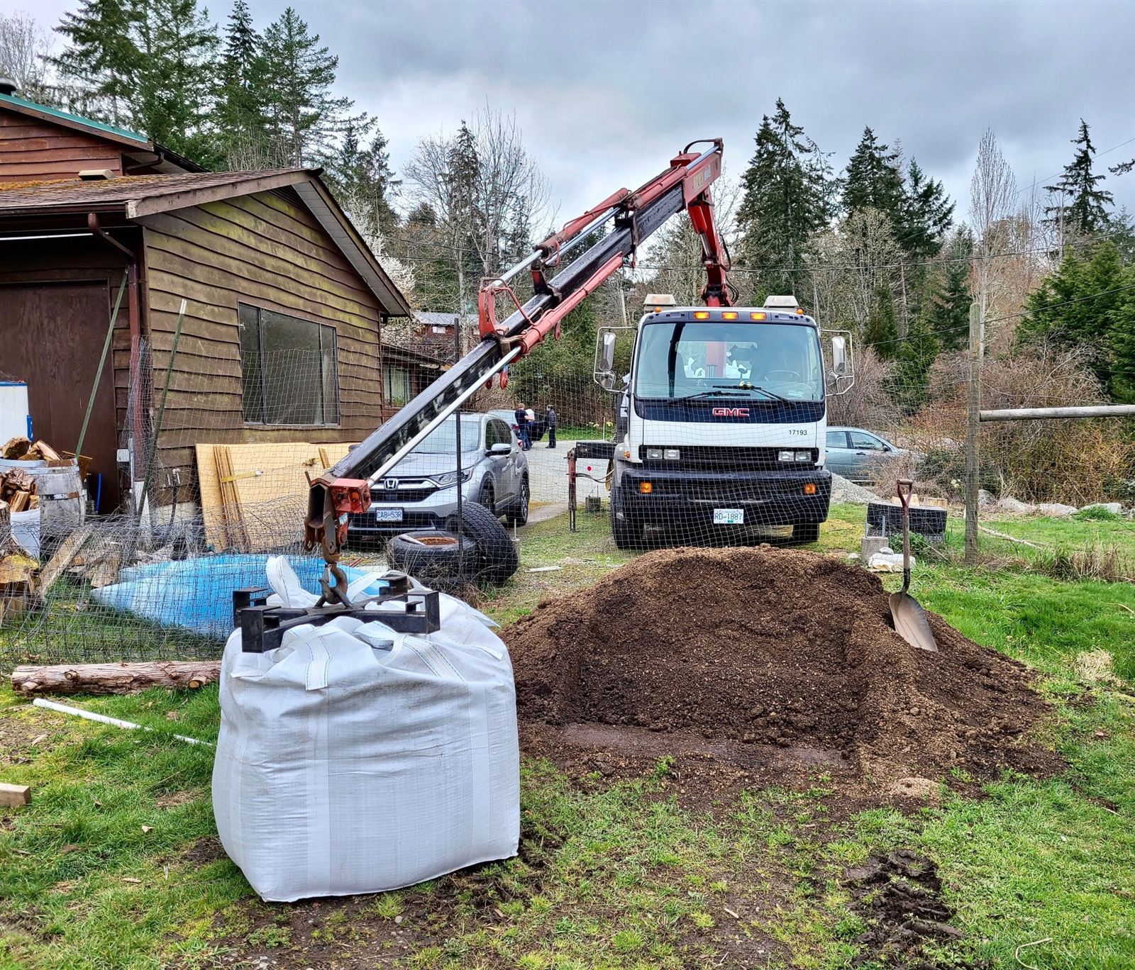 Steffich crane lowering a bulk bag of soil into a yard