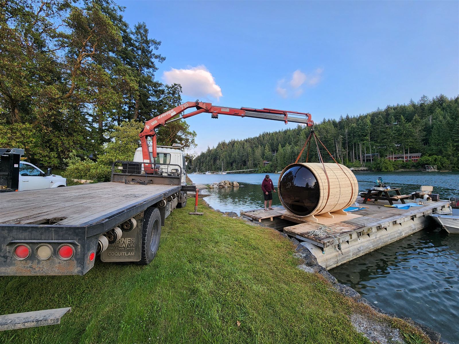 Crane setting a barrel sauna on a dock